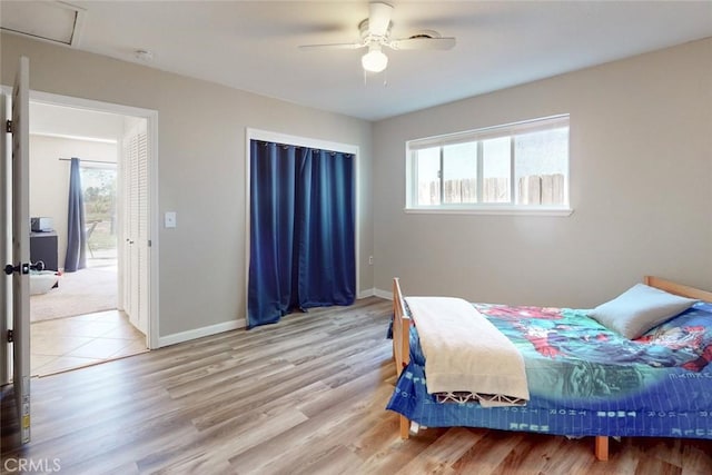 bedroom with light wood finished floors, baseboards, and ceiling fan