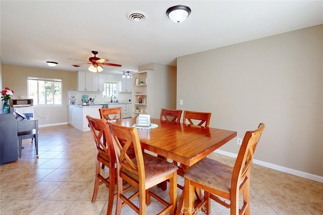 dining area with baseboards, a ceiling fan, visible vents, and light tile patterned floors