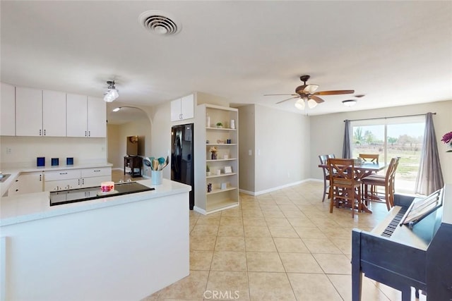 kitchen with freestanding refrigerator, visible vents, a ceiling fan, light countertops, and light tile patterned floors
