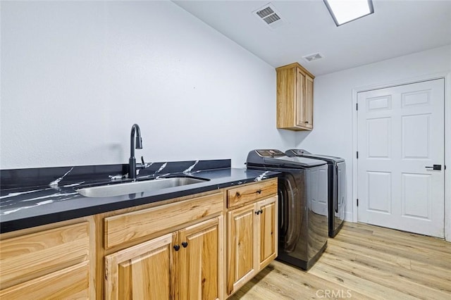 28383 Shady Oaks Rd, Clovis, CA 93619 - laundry room with visible vents, a sink, light wood-style floors, washing machine and clothes dryer, and cabinet space
