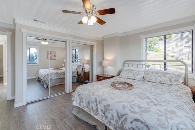 bedroom featuring multiple windows, ornamental molding, multiple closets, and visible vents
