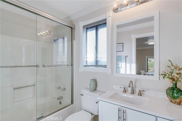 full bathroom with shower / bath combination with glass door, plenty of natural light, toilet, and vanity
