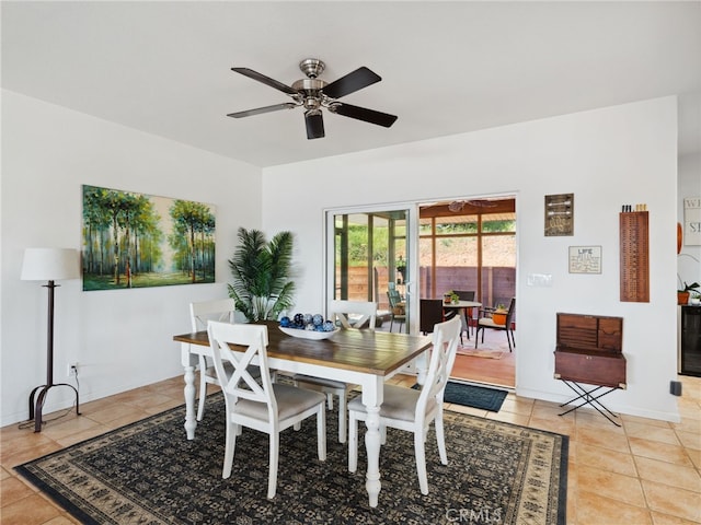 dining area featuring ceiling fan, baseboards, and light tile patterned floors