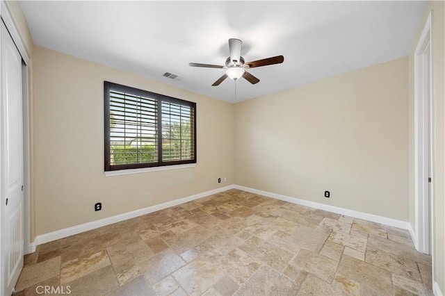 unfurnished bedroom featuring visible vents, a ceiling fan, stone tile flooring, a closet, and baseboards