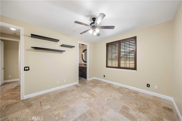 unfurnished bedroom featuring baseboards and stone finish floor