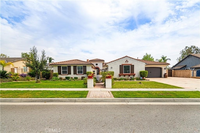 mediterranean / spanish-style home with a tiled roof, a front lawn, stucco siding, driveway, and a garage
