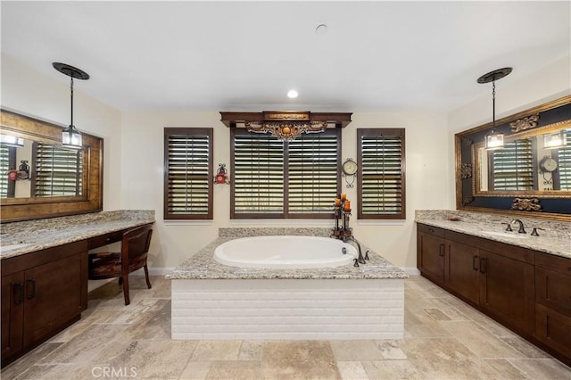 full bathroom featuring a garden tub, baseboards, a sink, and stone finish flooring