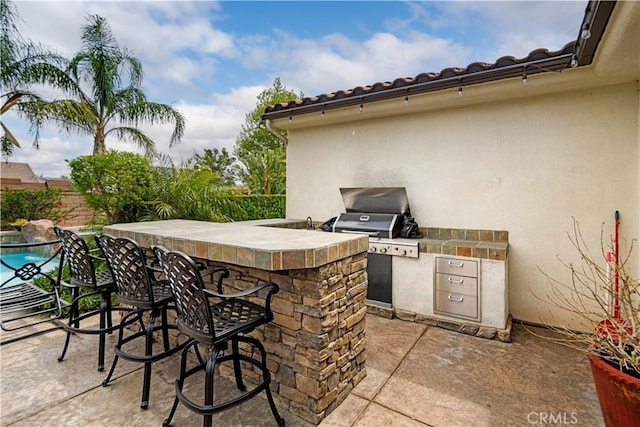 view of patio / terrace with outdoor wet bar and area for grilling
