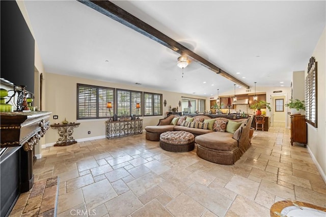 living area with baseboards, stone tile floors, beam ceiling, and a healthy amount of sunlight