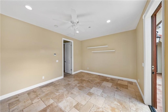 spare room with recessed lighting, stone tile flooring, a ceiling fan, and baseboards