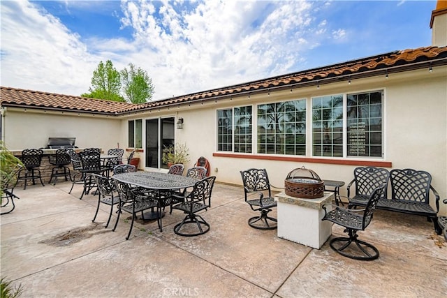 view of patio / terrace featuring outdoor dining space, a fire pit, and area for grilling