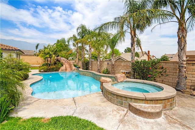 view of swimming pool with a fenced in pool, a fenced backyard, an in ground hot tub, and a mountain view
