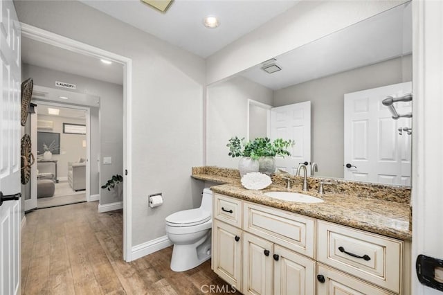 bathroom featuring recessed lighting, wood finished floors, toilet, vanity, and baseboards
