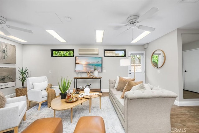 living room featuring baseboards, an AC wall unit, and ceiling fan