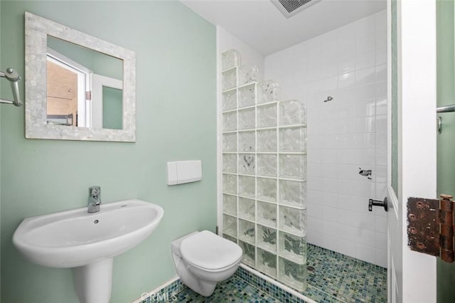 full bathroom featuring toilet, walk in shower, a sink, and visible vents