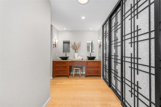 bathroom with recessed lighting, double vanity, wood finished floors, and baseboards