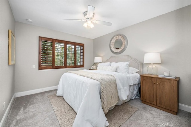 bedroom featuring baseboards, a ceiling fan, and light colored carpet