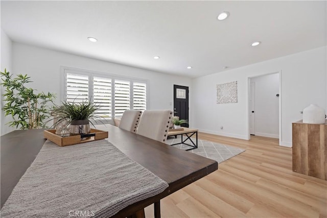 dining space with baseboards, light wood finished floors, and recessed lighting