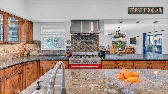 73950 22nd Ave, Desert Hot Springs, CA 92241 - kitchen featuring high end stove, wall chimney exhaust hood, brown cabinetry, and a healthy amount of sunlight