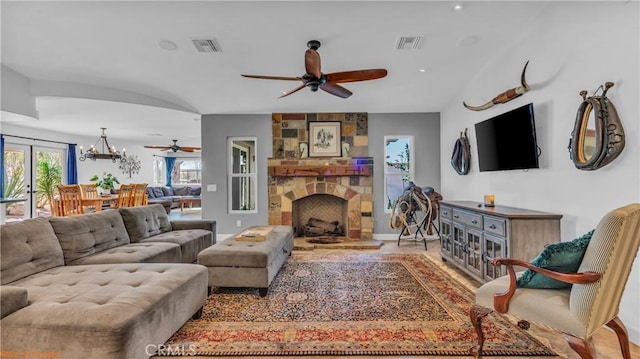 73950 22nd Ave, Desert Hot Springs, CA 92241 - living room featuring visible vents, ceiling fan with notable chandelier, and a stone fireplace