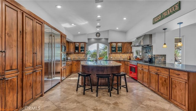 73950 22nd Ave, Desert Hot Springs, CA 92241 - kitchen featuring vaulted ceiling, built in appliances, wall chimney range hood, and brown cabinets