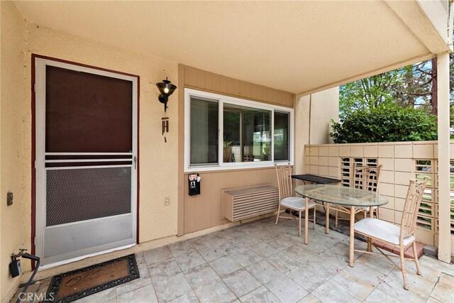 174 Avenida Majorca Unit A, Laguna Woods, CA 92637 - view of exterior entry featuring a patio area, outdoor dining space, and stucco siding