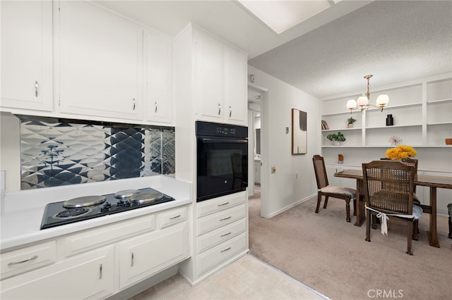174 Avenida Majorca Unit A, Laguna Woods, CA 92637 - kitchen featuring light countertops, black appliances, a chandelier, light colored carpet, and white cabinetry