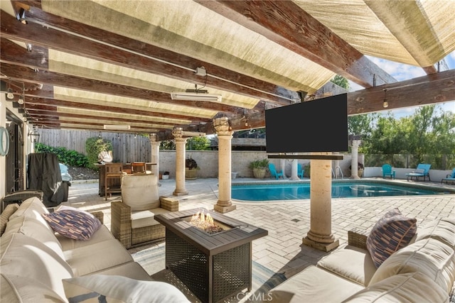 view of pool with a patio area, a fenced in pool, an outdoor living space with a fire pit, and a fenced backyard