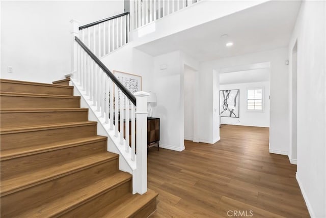 stairway featuring baseboards and wood finished floors
