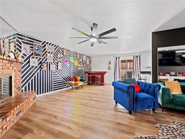 904 Pinon Dr, Barstow, CA 92311 - living area featuring a brick fireplace, a ceiling fan, wood finished floors, and a dry bar