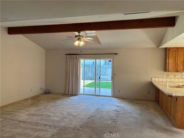 interior space with lofted ceiling with beams, visible vents, and light colored carpet