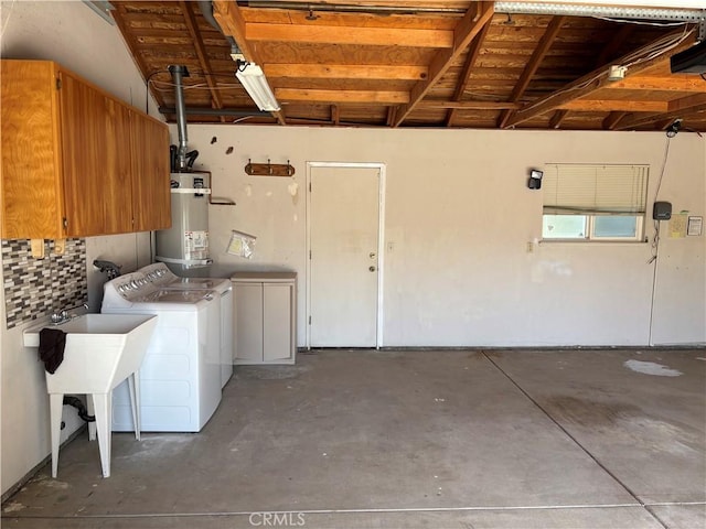laundry area with washer and clothes dryer and strapped water heater