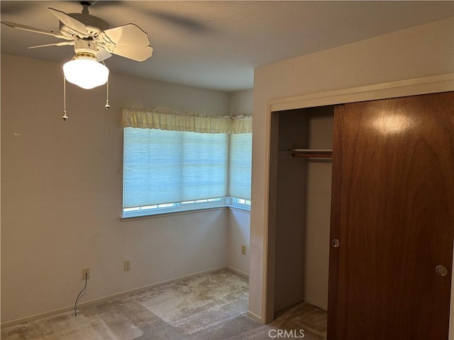 unfurnished bedroom featuring a ceiling fan, carpet flooring, and a closet