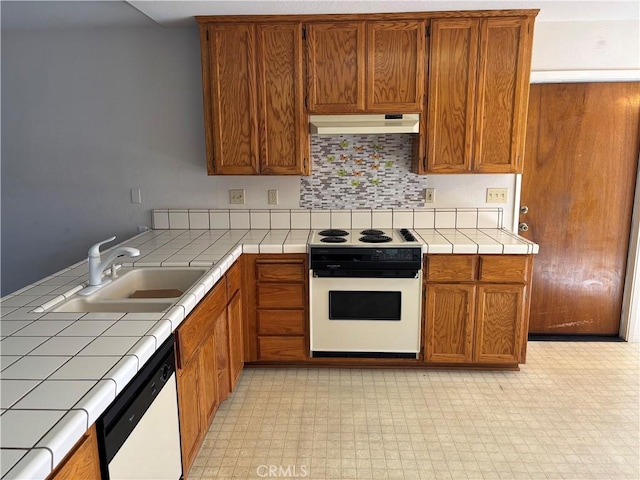 kitchen with tile counters, a sink, brown cabinets, white appliances, and under cabinet range hood