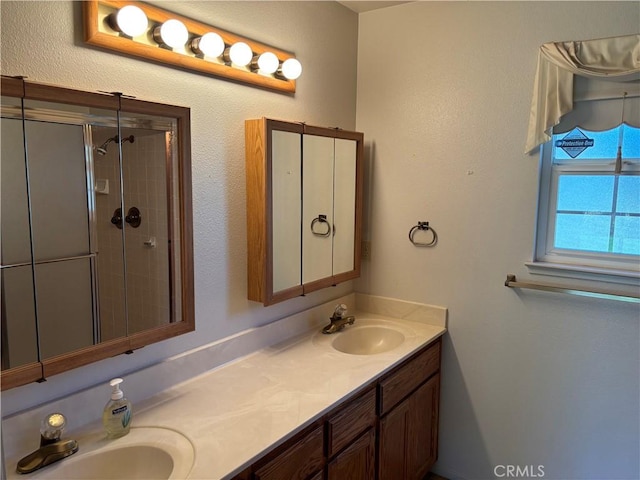 full bathroom featuring double vanity, a shower stall, and a sink