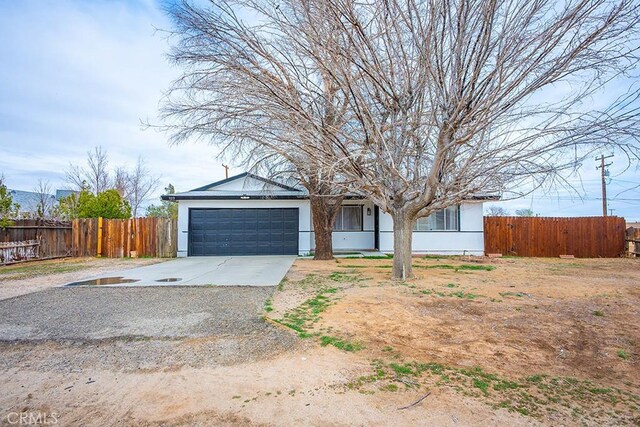 view of front facade with a garage, concrete driveway, and fence