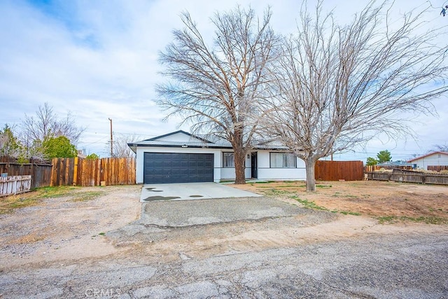 9213 Jacaranda Ave, California City, CA 93505 - view of front of home featuring a garage, driveway, and stucco siding
