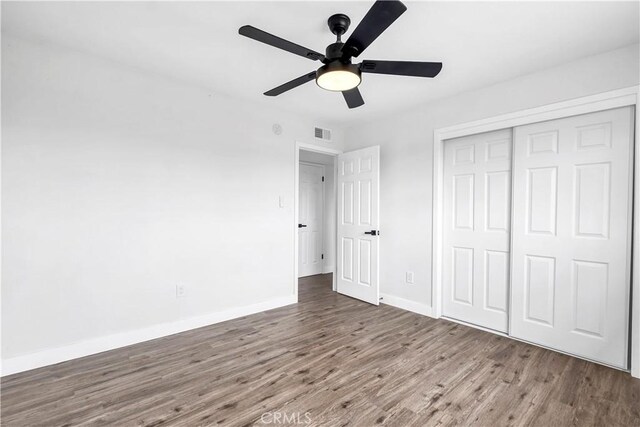 9213 Jacaranda Ave, California City, CA 93505 - unfurnished bedroom with wood finished floors, a closet, and a ceiling fan