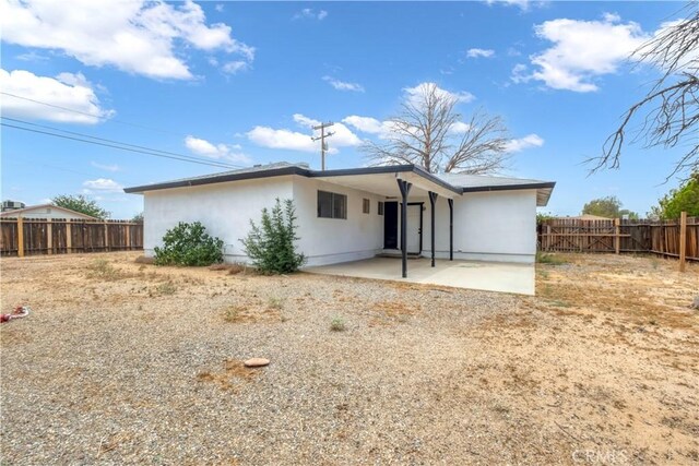 9213 Jacaranda Ave, California City, CA 93505 - back of property with a patio area, a fenced backyard, and stucco siding