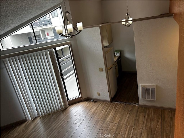 1 Appian Way Unit 710-6, San Francisco, CA 94080 - unfurnished dining area with a chandelier, plenty of natural light, wood finished floors, and a textured wall