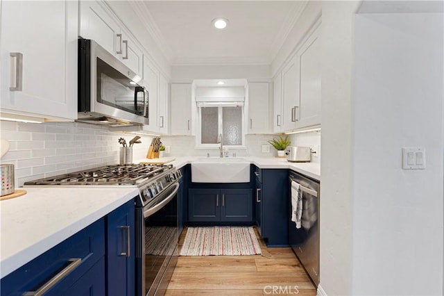 56 B Surfside Ave, Surfside, CA 90743 - kitchen with white cabinets, a sink, light wood-style floors, blue cabinetry, and appliances with stainless steel finishes