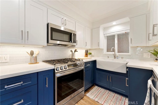 56 B Surfside Ave, Surfside, CA 90743 - kitchen featuring appliances with stainless steel finishes, blue cabinetry, ornamental molding, and a sink