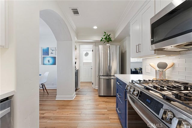 56 B Surfside Ave, Surfside, CA 90743 - kitchen with light wood finished floors, blue cabinetry, visible vents, appliances with stainless steel finishes, and white cabinetry