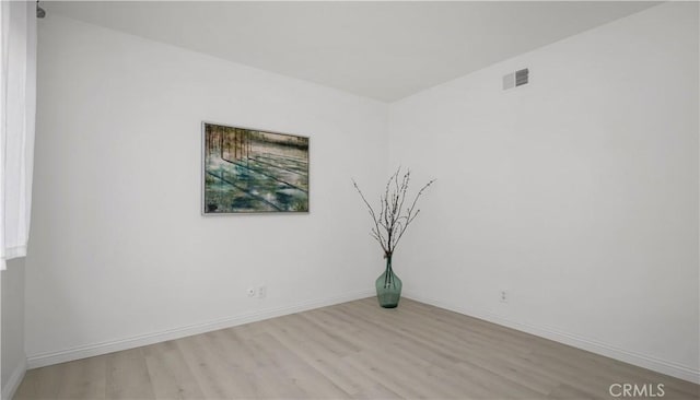 unfurnished room with visible vents, baseboards, and light wood-type flooring