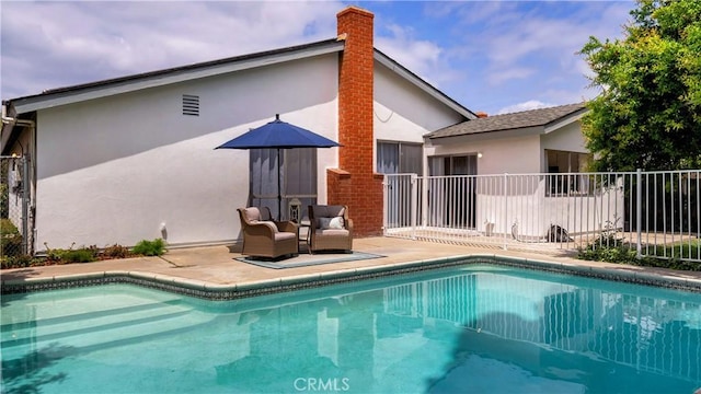 back of house featuring stucco siding, fence, an outdoor pool, and a patio area