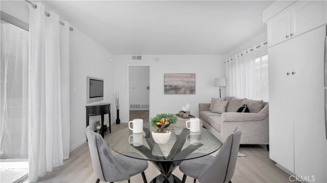 dining room with visible vents, baseboards, and light wood-style floors