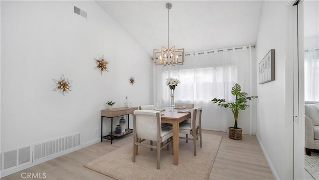 dining space with visible vents, baseboards, a chandelier, and light wood-style floors
