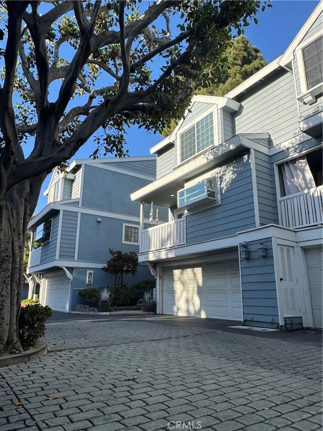 2218 Mayfair Ct, Costa Mesa, CA 92627 - view of side of property with a garage, decorative driveway, a balcony, and stucco siding