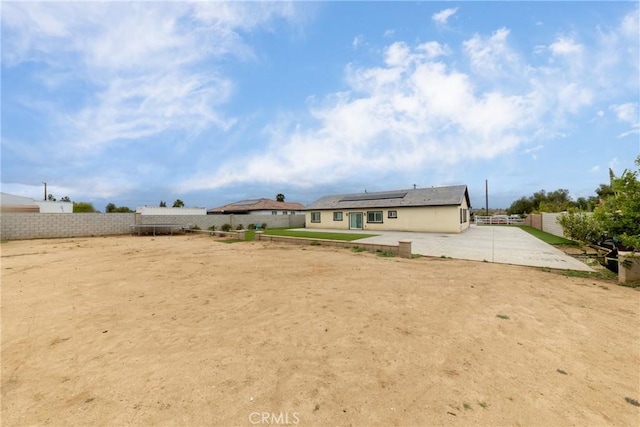 20109 Hunter St, Perris, CA 92570 - back of property with roof mounted solar panels, a fenced backyard, and a patio