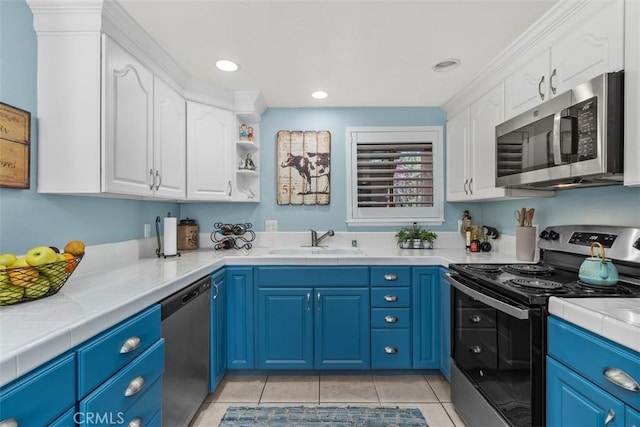 888 Ronda Sevilla Unit D, Laguna Woods, CA 92637 - kitchen with a sink, white cabinets, light tile patterned flooring, blue cabinetry, and appliances with stainless steel finishes